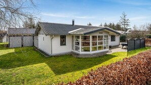 A single-story house with a sloped roof, a covered porch, and a fenced yard. - Gorgeous home in Tarm with WiFi (Tarm)