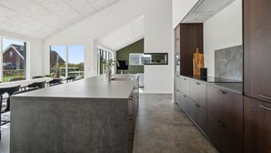 A modern kitchen with a large island, dark wood cabinets, and a view of the outdoors. - 5 bedroom gorgeous home in Skjern (Skjern)