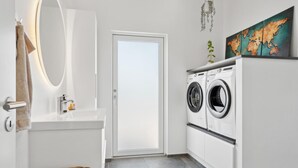 A compact laundry room with a washing machine and dryer, a sink, and a mirror. - 5 bedroom gorgeous home in Skjern (Skjern)