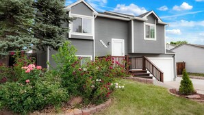 A two-story residential house with a grey exterior, white trim, and a front porch. - Stylish 4BR Retreat - Hot Tub, Game Room & Modern Comforts (Westminster)
