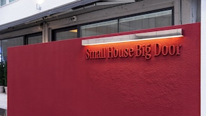 A red sign with the text "Small House Big Door" on a building facade. - Small House Big Door Myeongdong (Seoul)