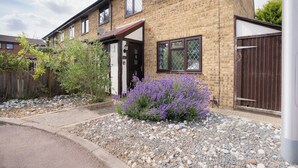 A brick house with a front door, a satellite dish, and a garden with purple flowers. - Everglades Hideaway in Gillingham (Gillingham)