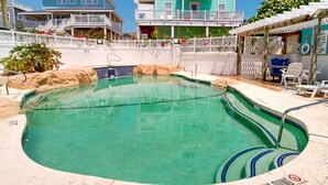 A swimming pool with a wooden deck, a lifeguard stand, and a no diving sign.