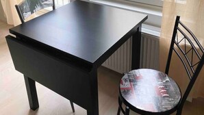Une petite pièce avec une fenêtre, une table et deux chaises.
