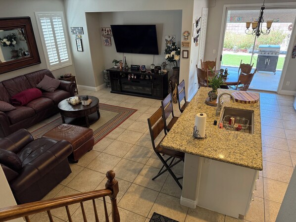 A modern living room with a brown leather sofa, a coffee table, and a TV mounted on the wall. - Sweet home with electric car charger
unwind, relax enjoy a great time in Vegas (Henderson)
