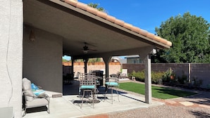A covered patio area with outdoor furniture, a ceiling fan, and a view of the backyard. - Sweet home with electric car charger 
 unwind, relax enjoy a great time in Vegas (Henderson)