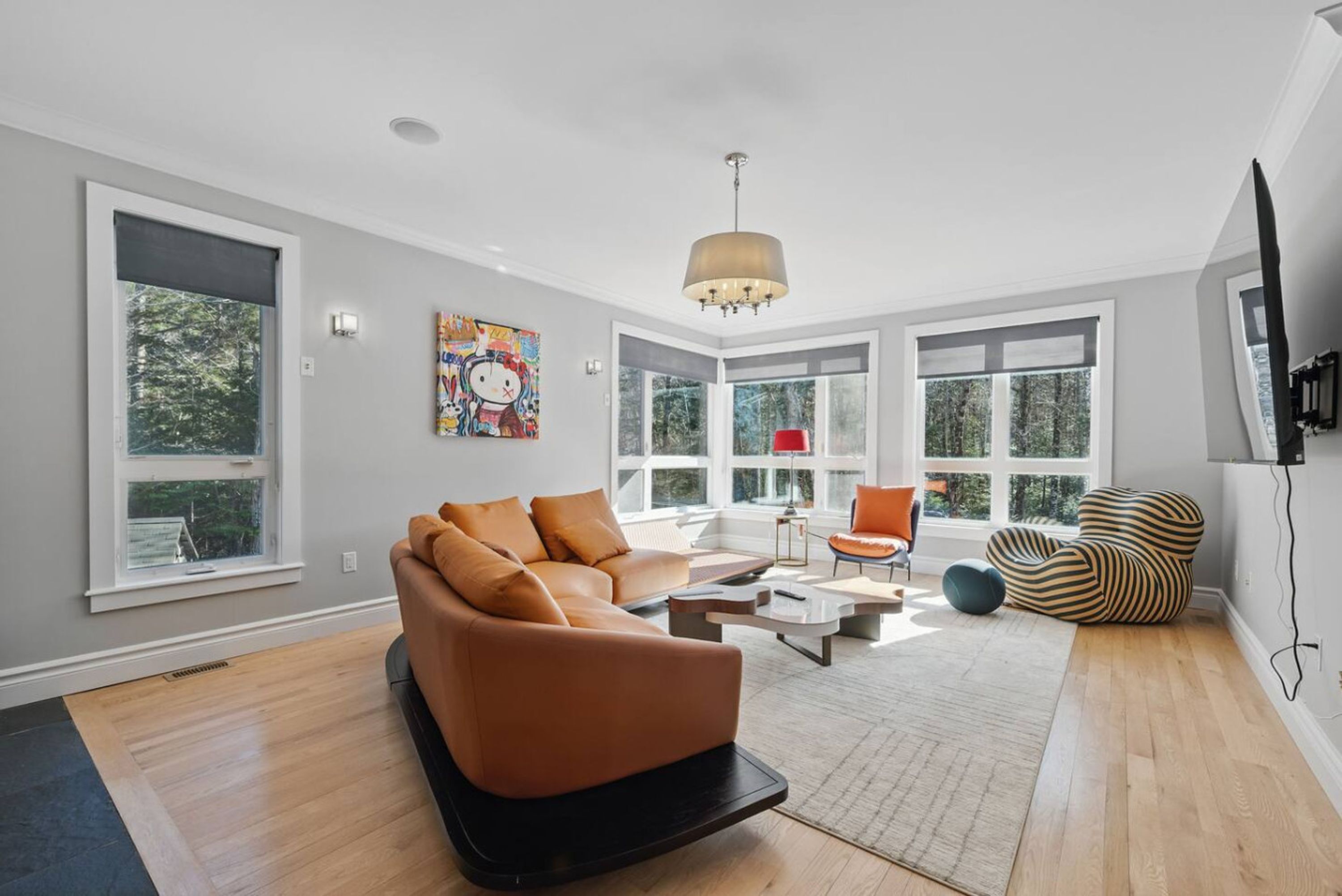 A modern living room with a sectional sofa, a coffee table, and a patterned bean bag.