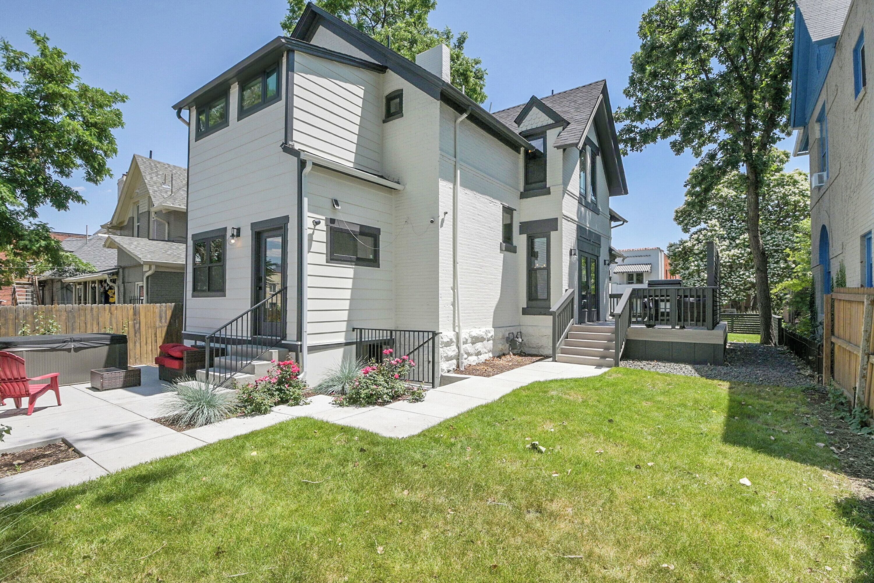 A two-story house with a front porch, a small garden, and a visible staircase leading to the second floor.