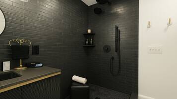 A modern bathroom with a black brick wall, a gold vanity, a black shower, and a white toilet.