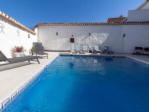 A swimming pool with lounge chairs and a small bar area. - Beautiful rural house with swimming pool and barbecue (Cozvíjar)