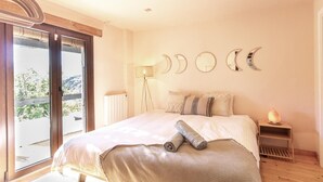 A bedroom with a large bed, a floor lamp, and a view of the outdoors. - Beautiful house with pool in the heart of the Lecrín Valley (Restábal)