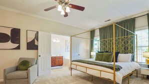 A four-poster bed with a canopy, a grey armchair, and abstract wall art. - Save Big! Kent Terrace - 3br in Alabaster (Alabaster)
