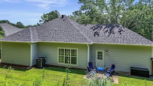 A single-story house with a sloped roof, a front door, and a small patio with two chairs and a table. - Save Big! Kent Terrace - 3br in Alabaster (Alabaster)
