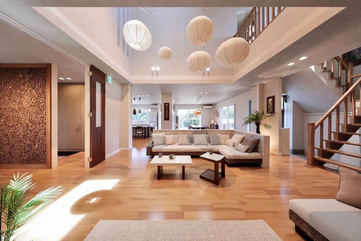 A spacious living area with a large sectional sofa, a coffee table, and a staircase.