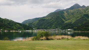 A lake surrounded by lush green hills and a small settlement.