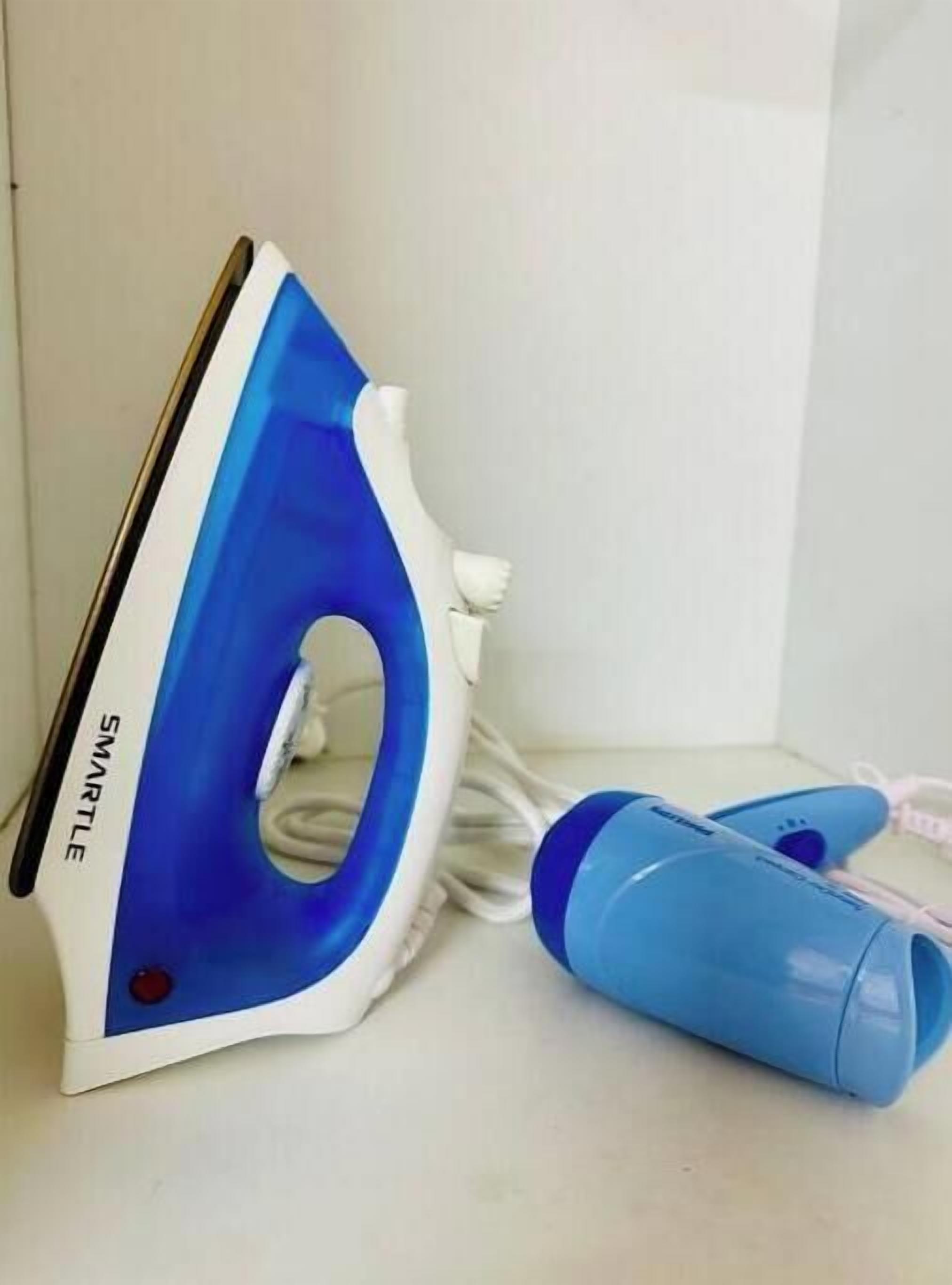 Un cepillo para la ropa azul y blanco con un cable, sobre una superficie blanca.