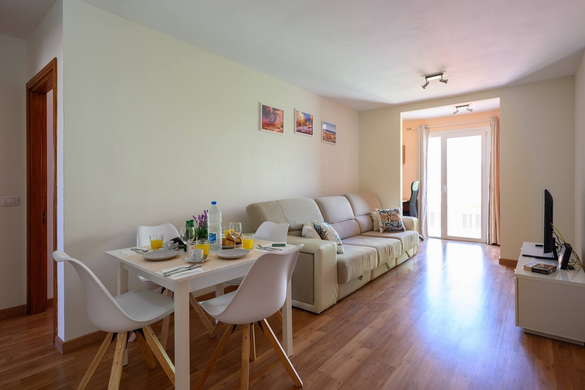 Een moderne woonkamer met een eethoek, een bank en een televisie.