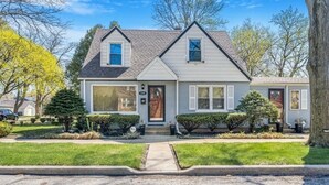 A two-story house with a gabled roof, a front porch, and a well-maintained lawn.