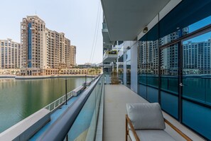 A balcony with a view of a river and high-rise buildings.
