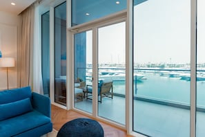 A modern living room with a large window overlooking a marina.