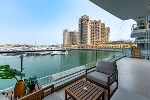 Un balcon donnant sur une marina et un grand bâtiment d’hôtel.