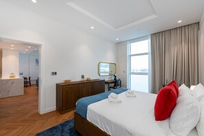 Een moderne hotelkamer met een groot bed, een bureau en uitzicht op de stad.