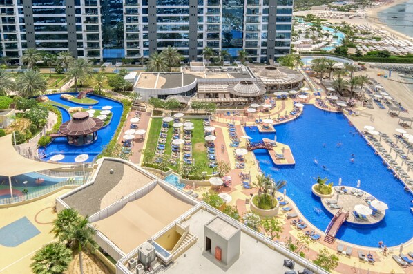 A resort with a large central pool, multiple smaller pools, and a beach area.