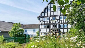 A traditional half-timbered house with a garden in front.