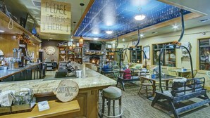 A cozy bar area with a wooden counter, bar stools, and a sign that reads "Please order here."