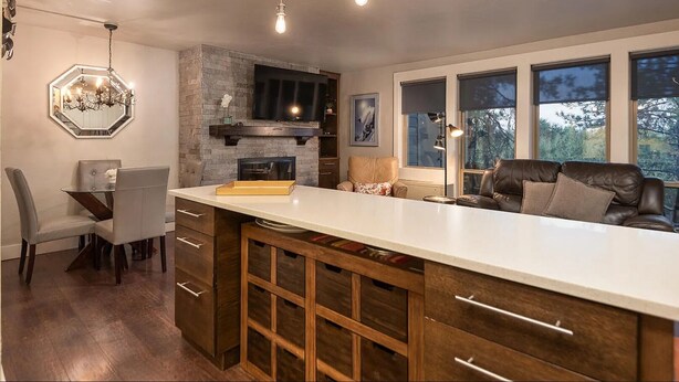 A modern kitchen with a large island, built-in appliances, and a fireplace.