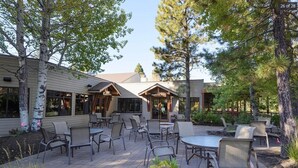 A patio area with outdoor seating and a building labeled "Rimrock Bar".