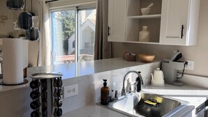 Una cocina moderna con encimera de mármol, lavabo integrado e iluminación empotrada.