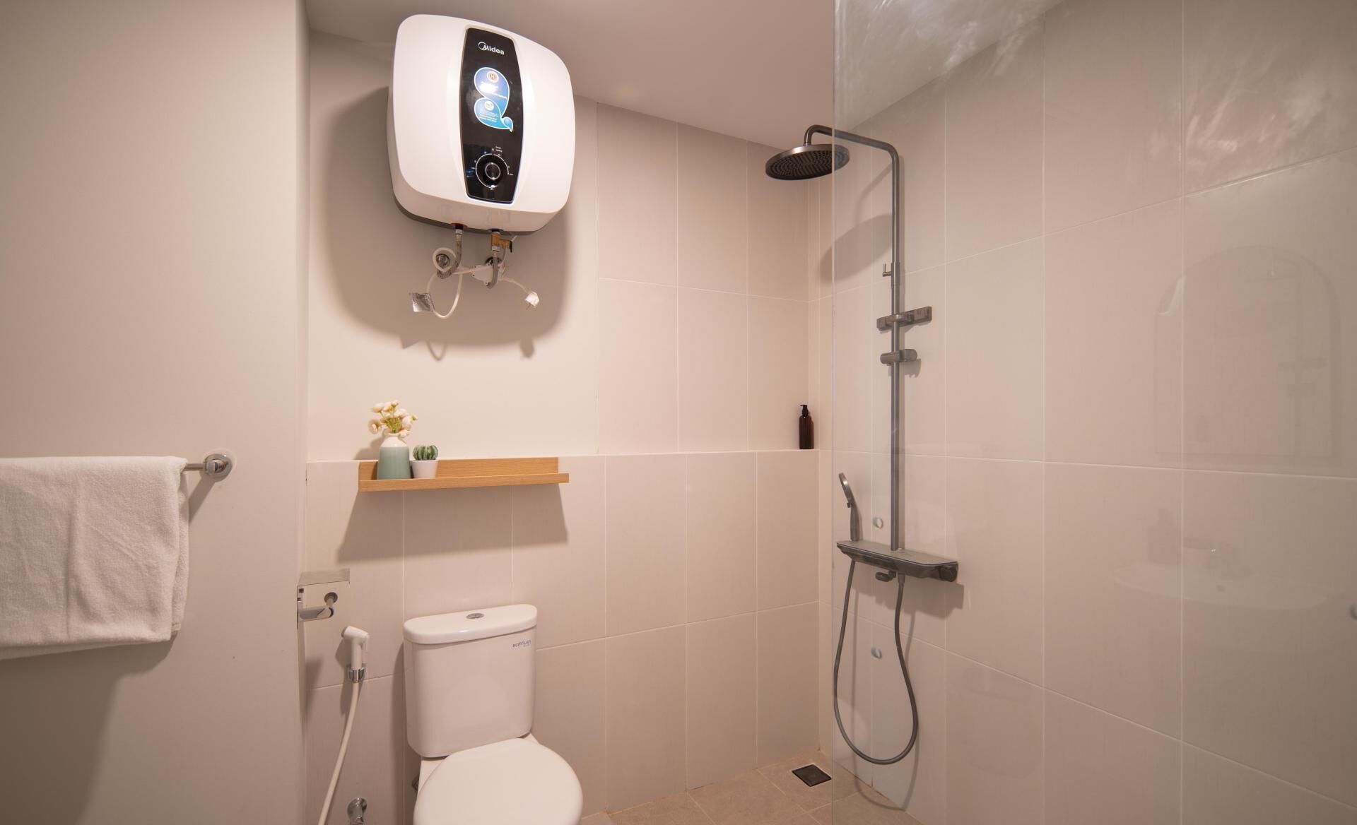 Un baño moderno con inodoro, ducha y calentador de agua instalado en la pared.