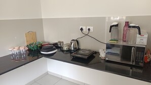A kitchen with a black countertop, stainless steel appliances, and various kitchen items.