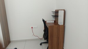 A corner office with a wooden desk, a chair, and a whiteboard on the wall.