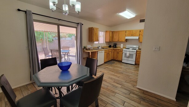A compact kitchen with wooden cabinets, a stove, and a dishwasher.