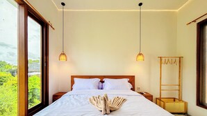 A neatly made bed with a decorative centerpiece, a wooden headboard, and two hanging lamps. - Budayana Villa (Jimbaran)