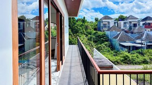 A balcony with a view of neighboring houses and greenery. - Budayana Villa (Jimbaran)