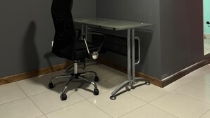 A corner room with a desk, chair, and a door.