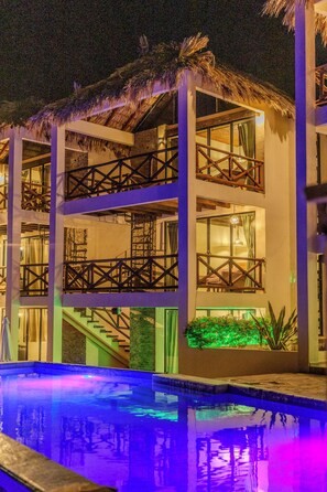 Hotel de varios pisos con zona de piscina en la planta baja.