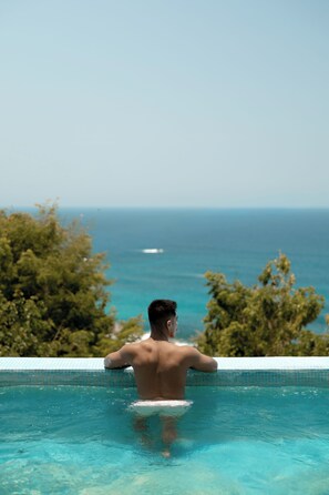 A person in a swimming pool with a view of the ocean. - Casa Sacre (San Pedro Pochutla)