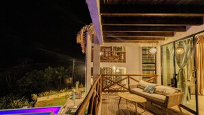 A wooden deck with a pool, a sofa, and a staircase leading to an upper level. - Casa Sacre (San Pedro Pochutla)
