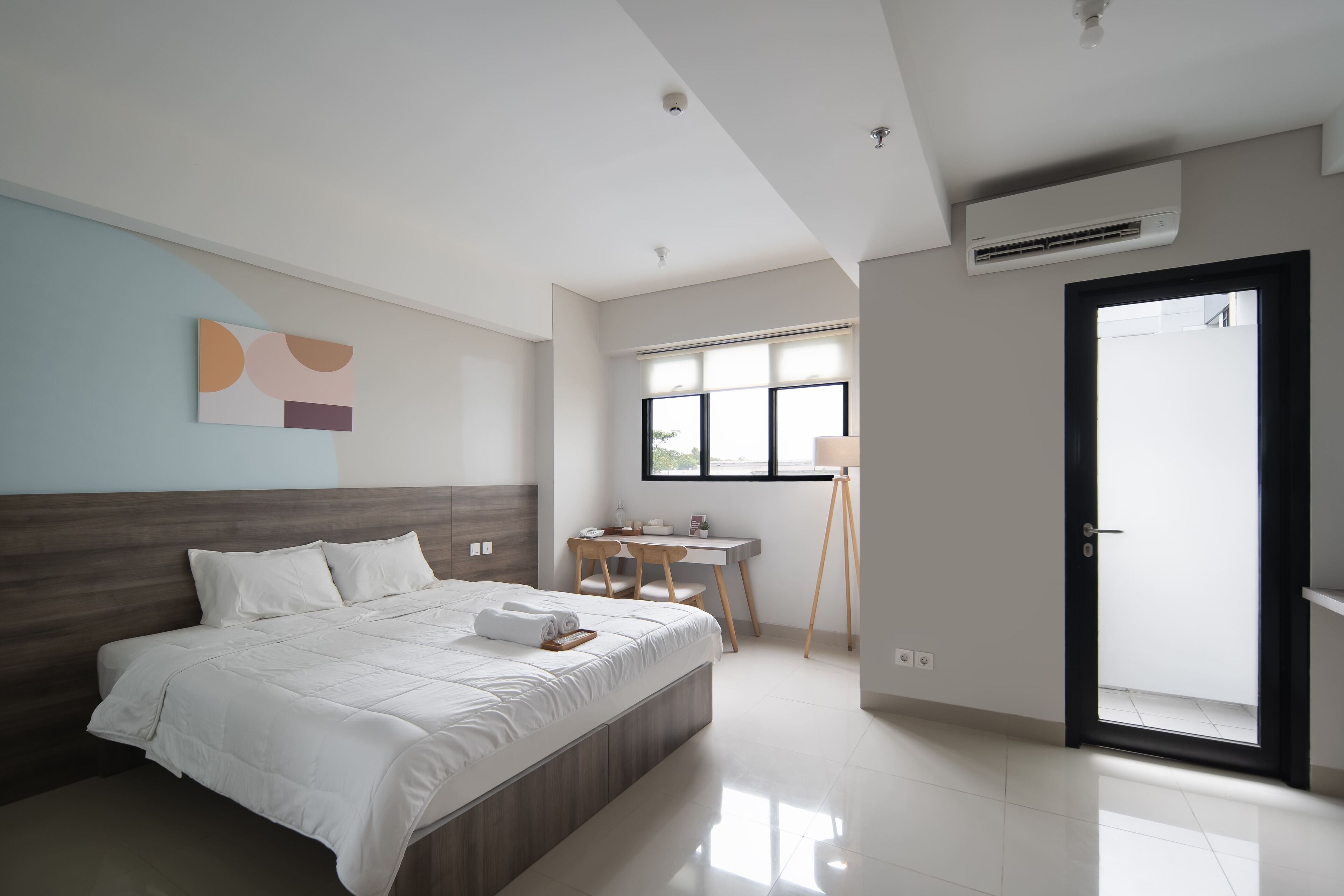Une chambre moderne avec un grand lit, un bureau et une chaise.