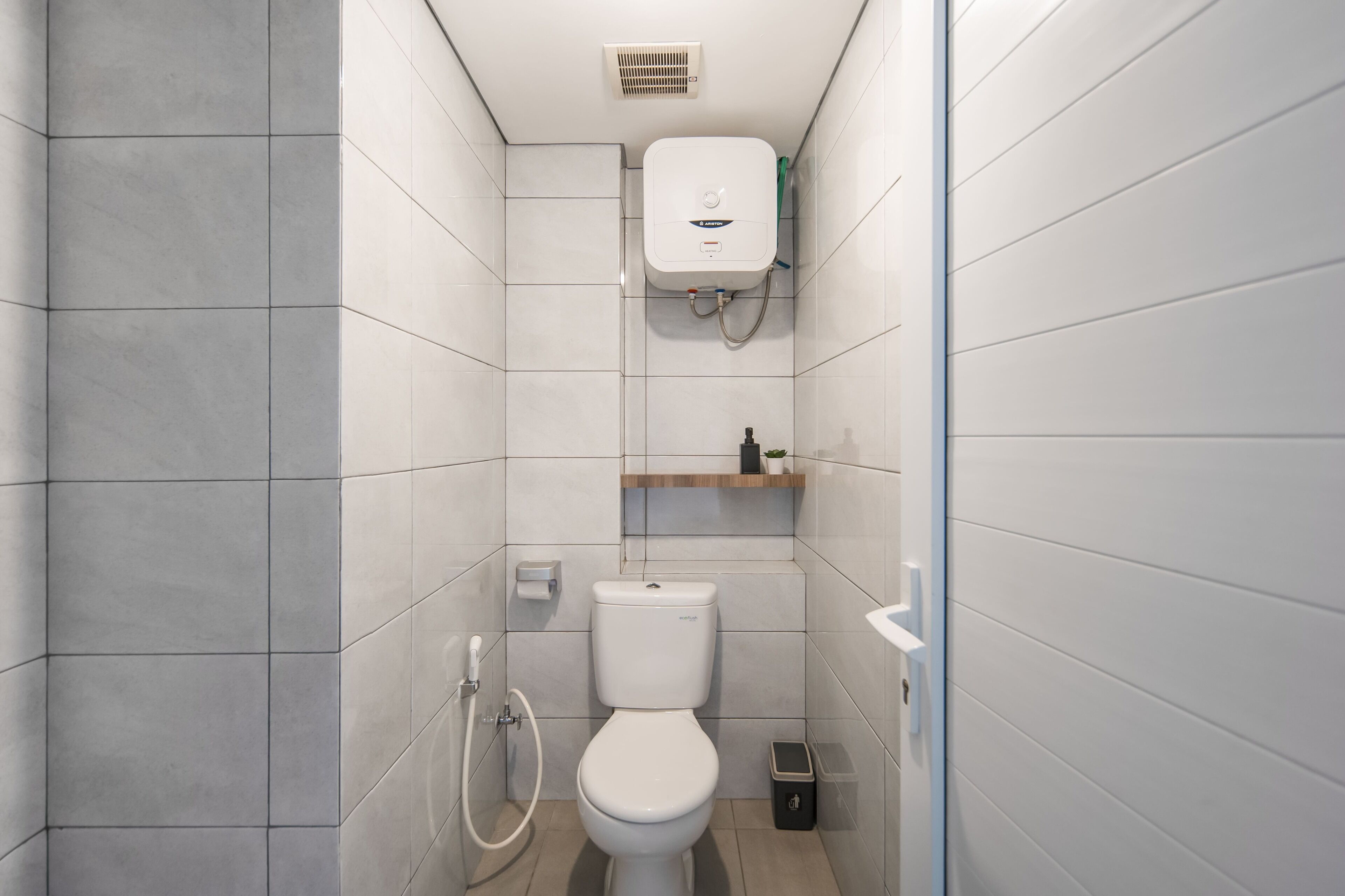 Une salle de bain moderne équipée de toilettes, d’une douche et d’un radiateur intégré.