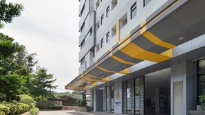 A modern building with a flat roof and a yellow and grey awning. - Cove Aspena Residence (Tangerang)