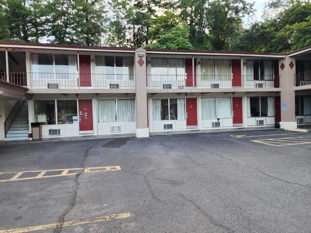 A two-story motel with a parking lot in front.