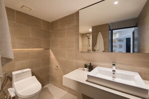 Une salle de bain moderne équipée de toilettes, d’un lavabo et d’une douche.