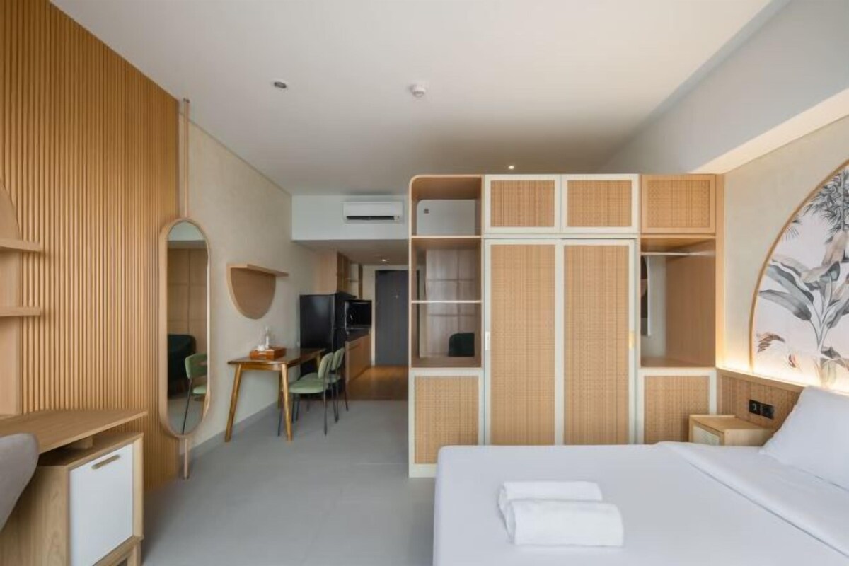 Una habitación de hotel moderna con cama, escritorio y armario.