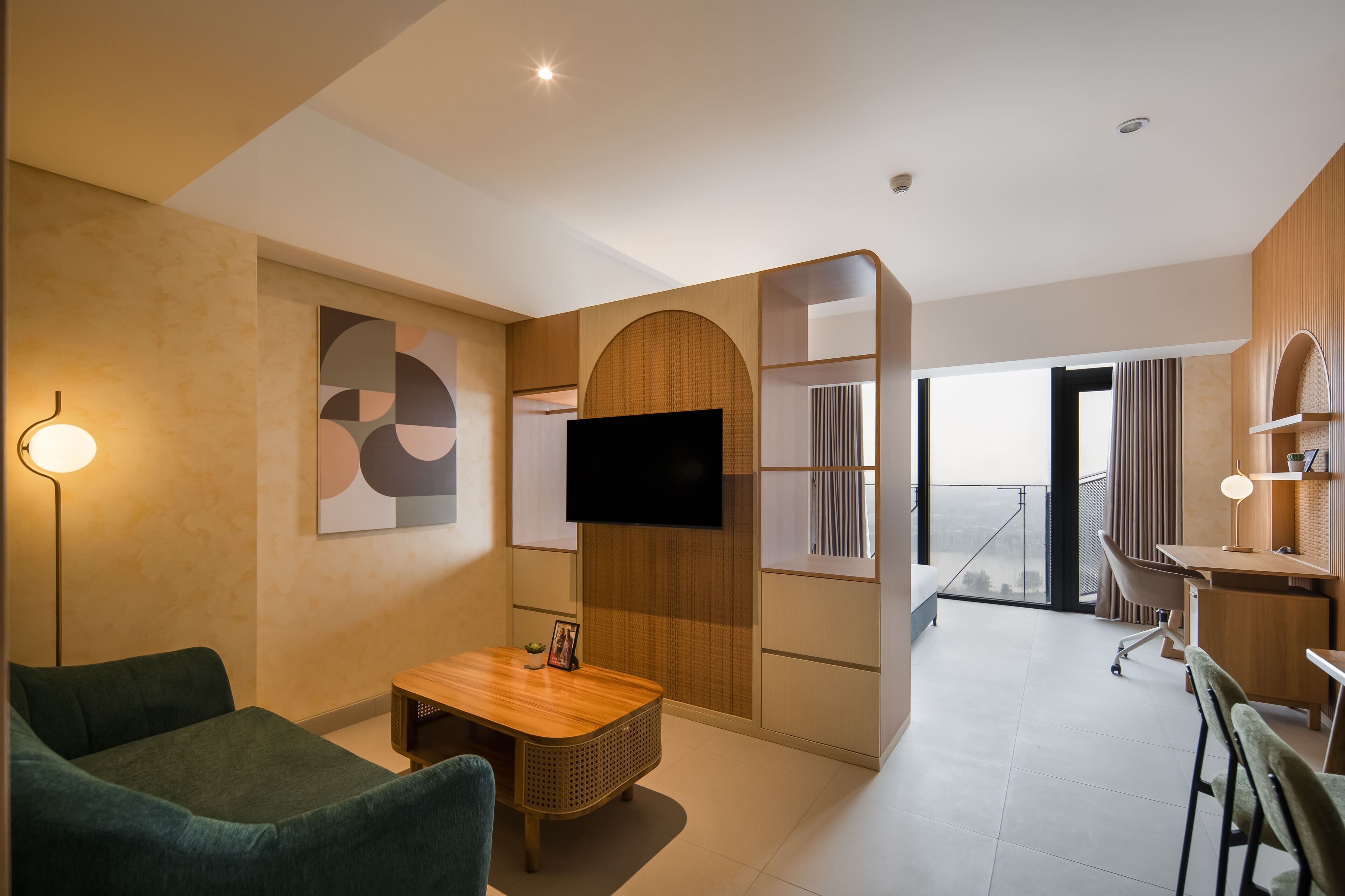 A modern living room with a flat-screen TV, a wooden coffee table, and a green sofa.