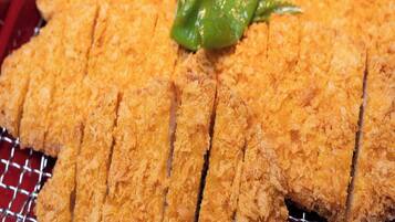 Un plat amb aliments refrits i empanats, probablement un plat japonès, i un guarniment de chili verd.